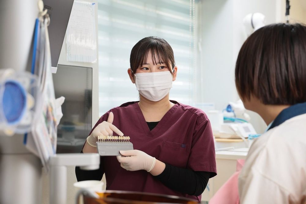 歯の色の見本を使ってカウンセリングをしている様子